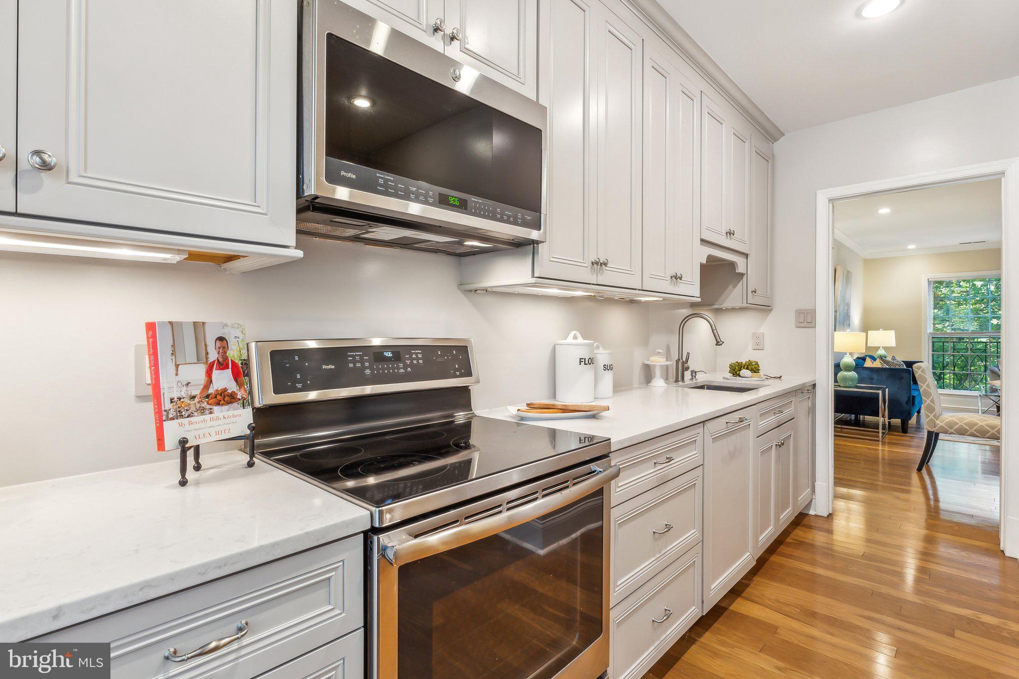 3205 Sutton Place Northwest, Unit A Washington, DC 20016 - Photo 13 of 44 a kitchen with stainless steel appliances white cabinets and a stove top oven