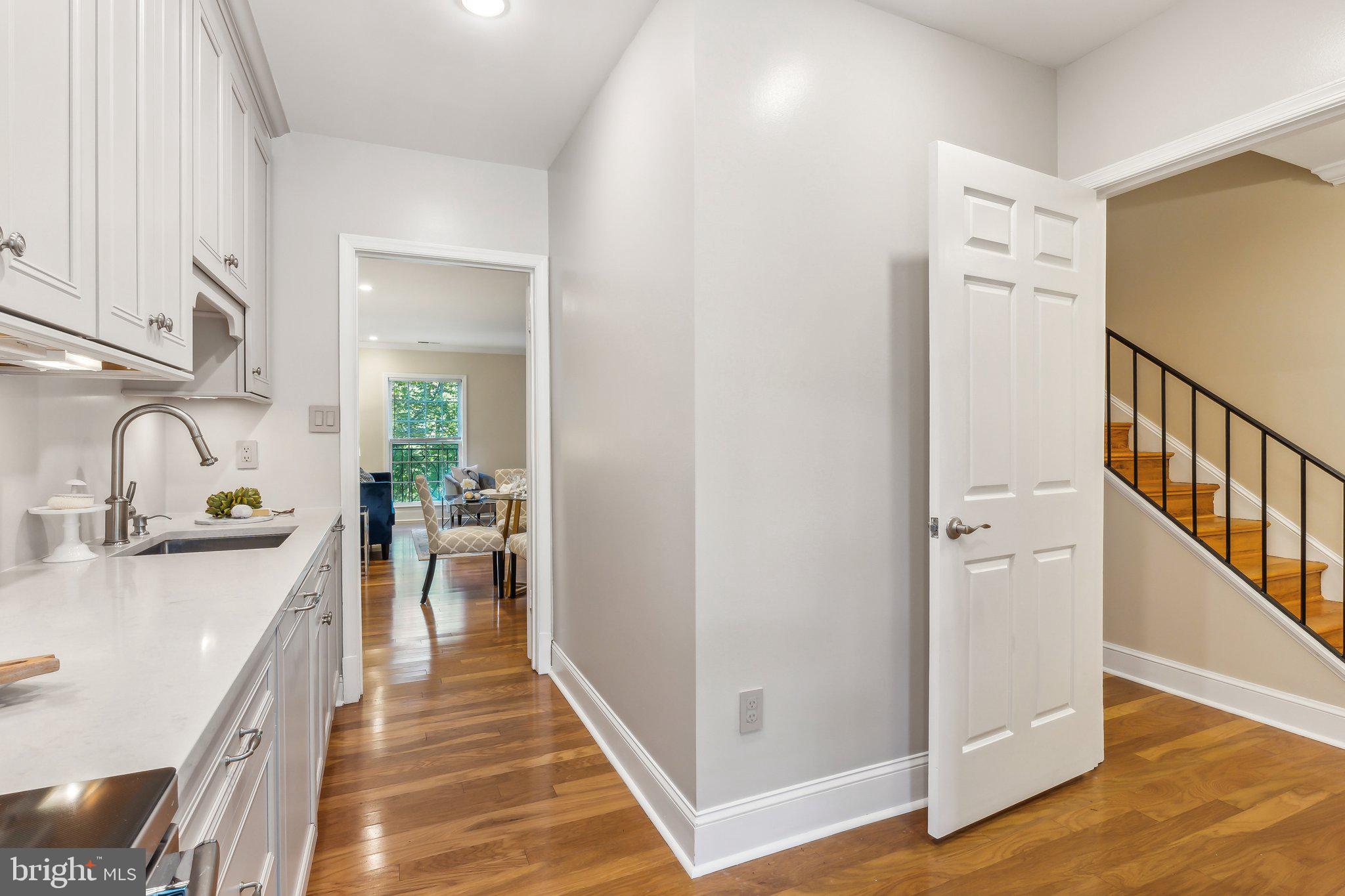 3205 Sutton Place Northwest, Unit A Washington, DC 20016 - Photo 15 of 44 a hallway with white cabinets and wooden floor