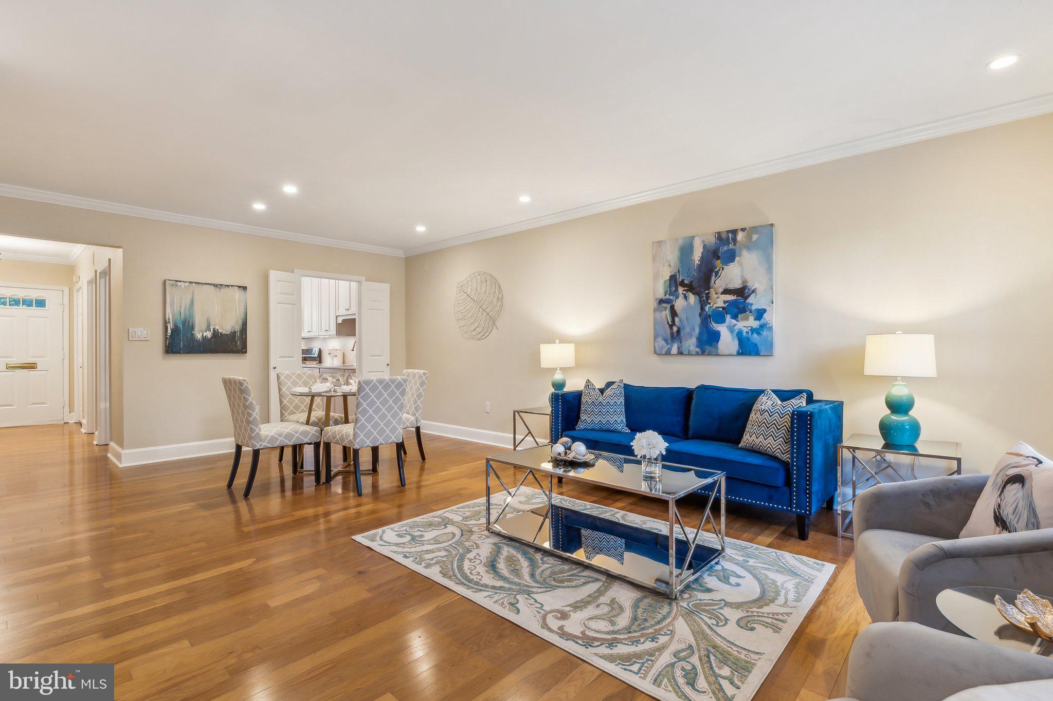 3205 Sutton Place Northwest, Unit A Washington, DC 20016 - Photo 6 of 44 a living room with furniture and a dining table with wooden floor