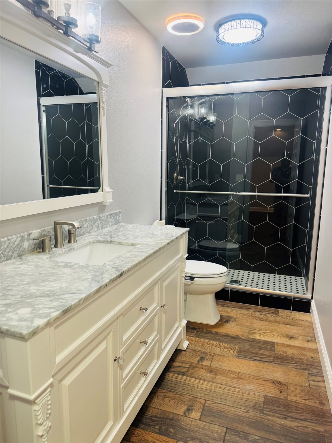 5317 Higgins Street Houston, TX 77033 - Photo 36 of 50 a bathroom with a granite countertop sink a toilet a mirror and shower