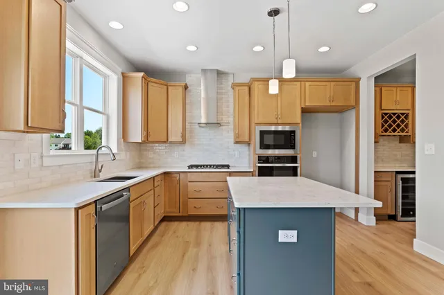 a kitchen with a sink a counter top space stainless steel appliances and a window