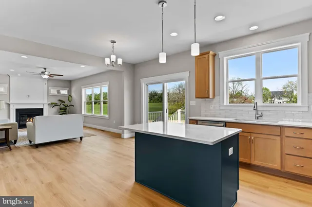 a large kitchen with kitchen island a large counter space a sink appliances and a window