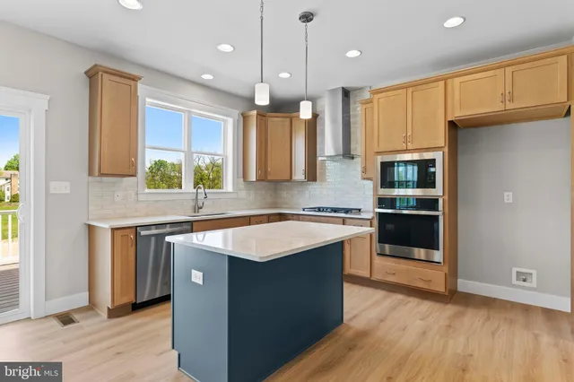 a kitchen with stainless steel appliances granite countertop a sink a stove and a refrigerator