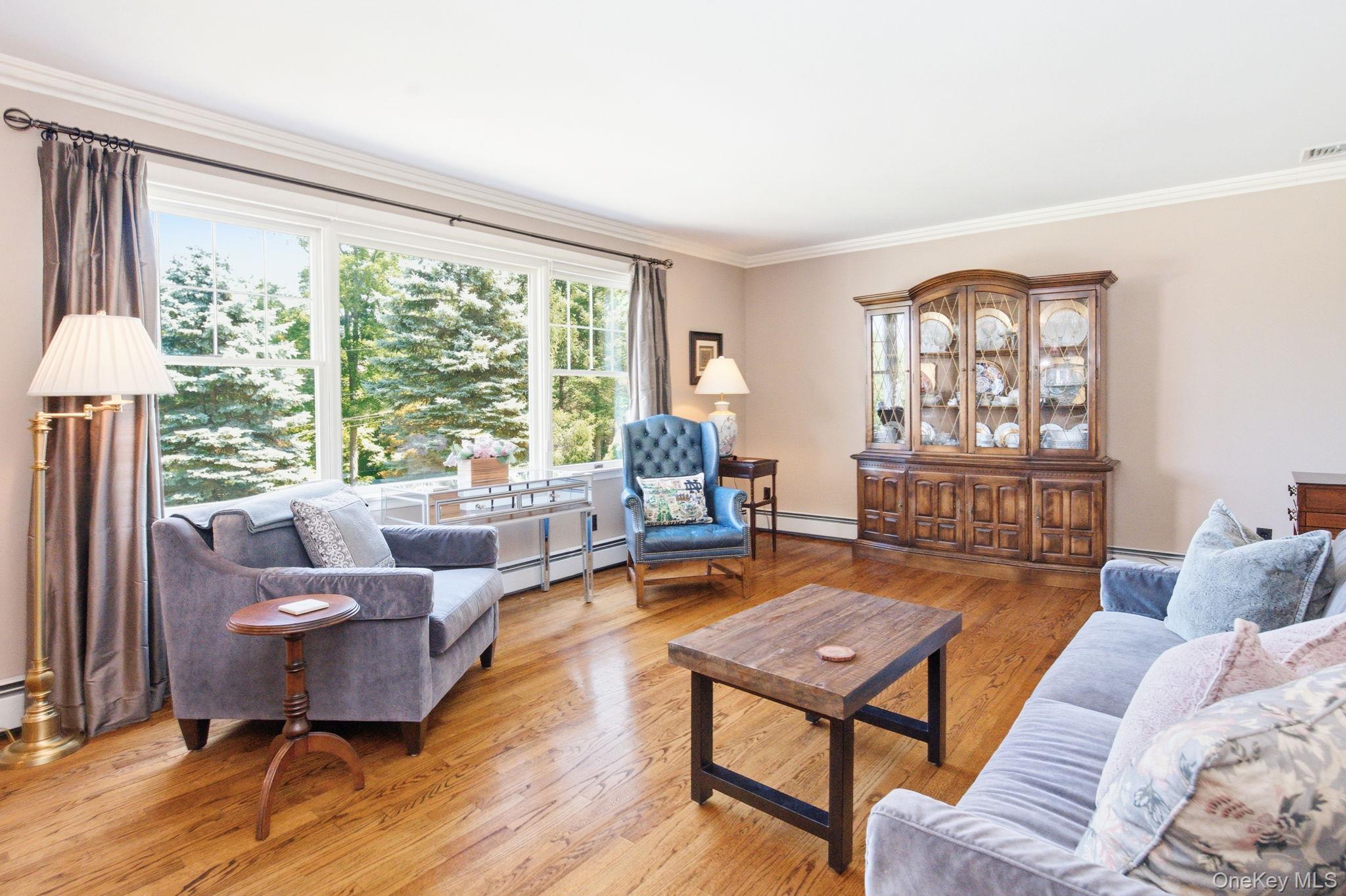 32 Bedell Road Katonah, NY 10536 - Photo 5 of 49 The oversized living room stretches beneath crown molding toward a wall of windows.