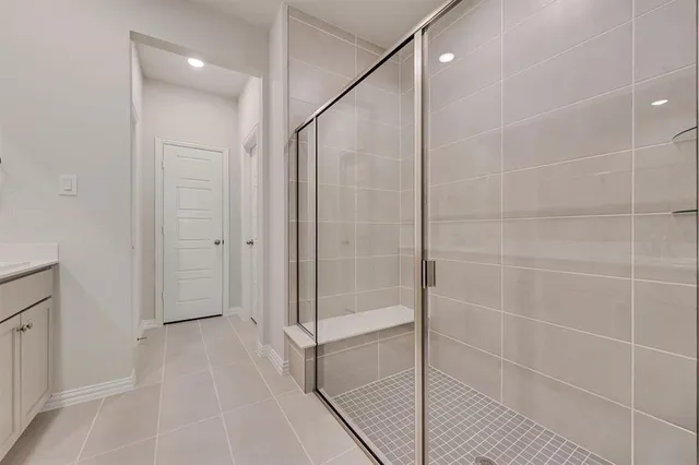 a bathroom with a shower and a glass door