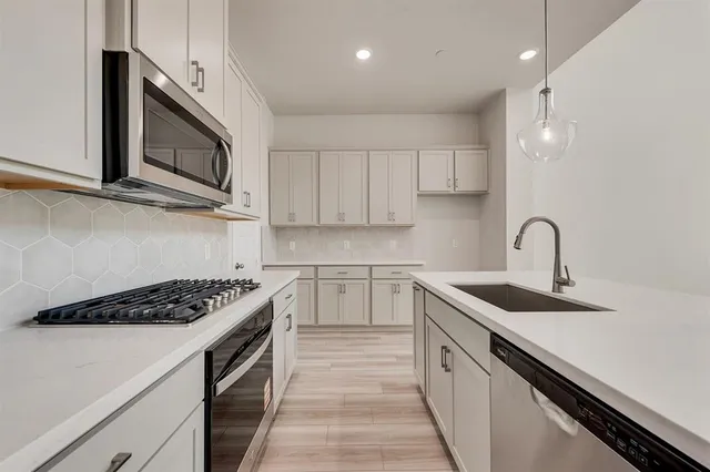 a kitchen with stainless steel appliances granite countertop a sink stove and microwave