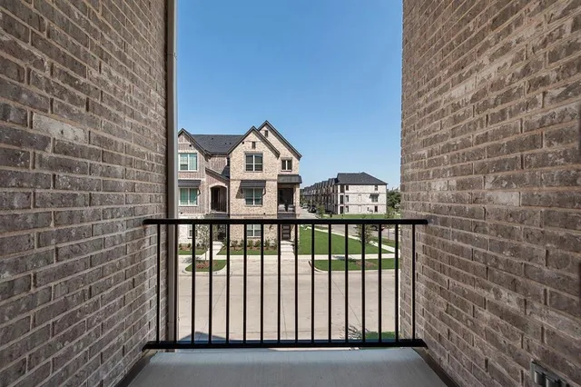 a view of a brick house with wooden fence