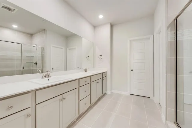 a spacious bathroom with a double vanity sink and a mirror