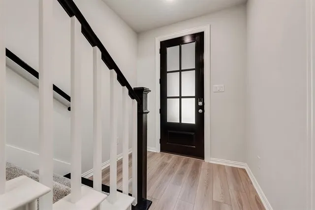 a view of entryway and hall with wooden floor