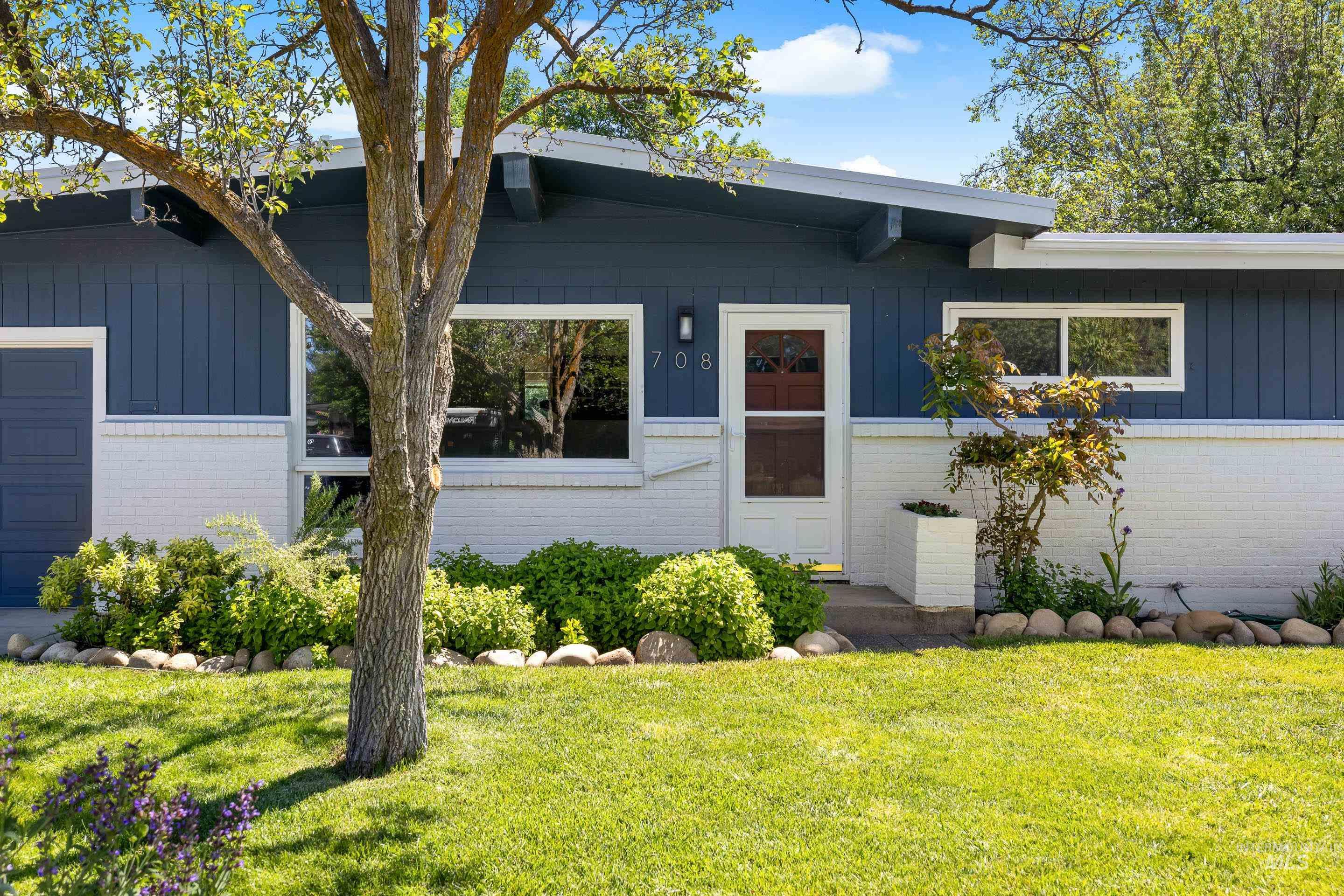 708 South Phillippi Street Boise, ID 83705 - Photo 2 of 25 Mid-century modern exterior featuring deep blue vertical siding and a white brick facade