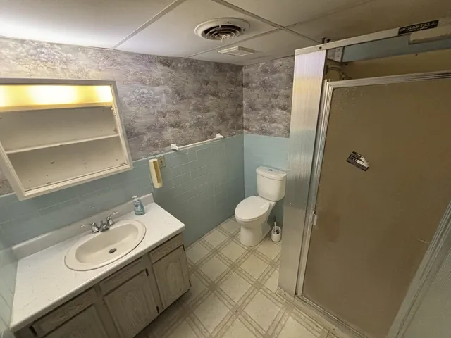 a bathroom with a sink a toilet and shower