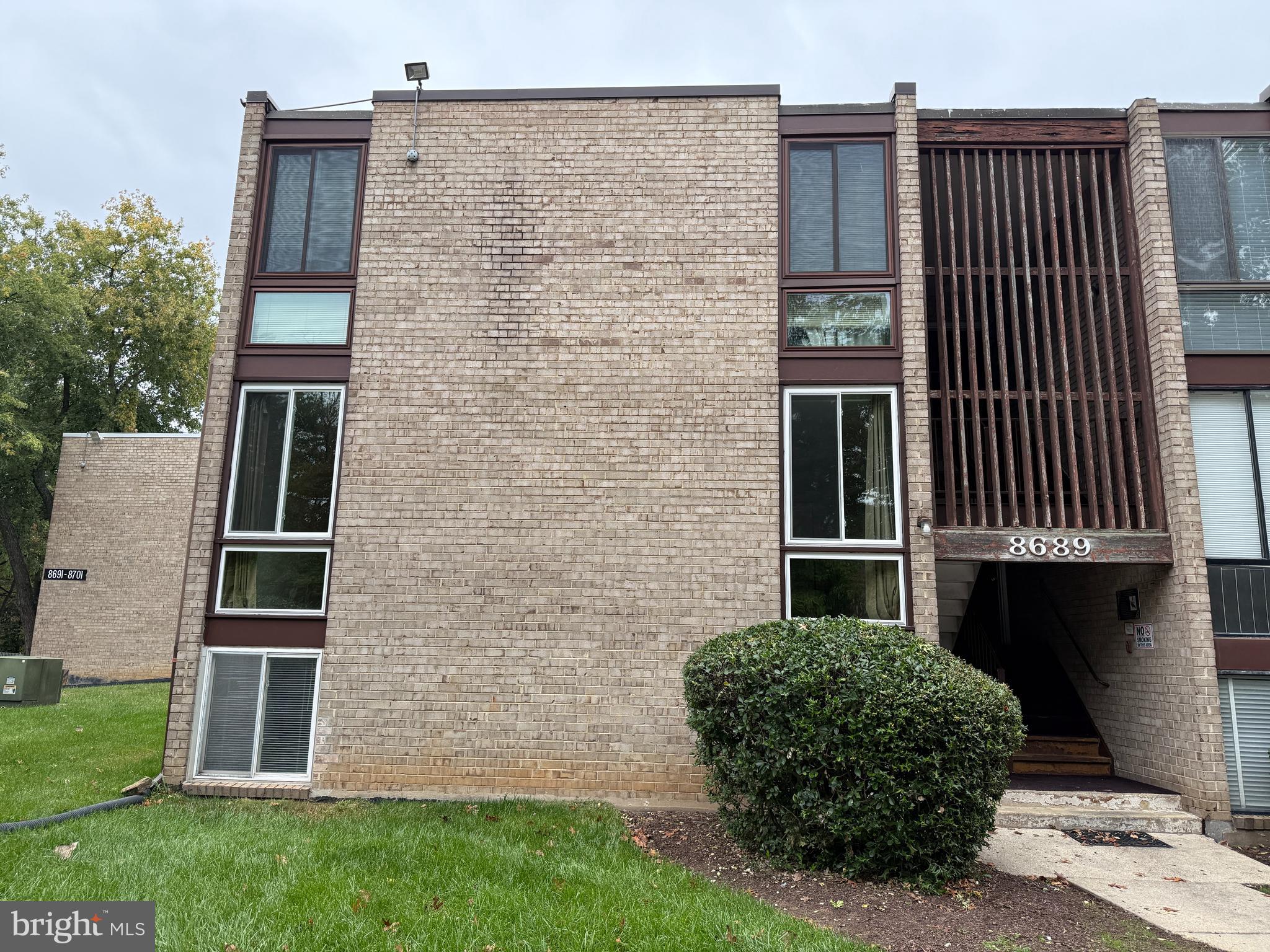 8689 Greenbelt Road, Unit 101 Greenbelt, MD 20770 - Photo 1 of 27 a front view of a house with a garden