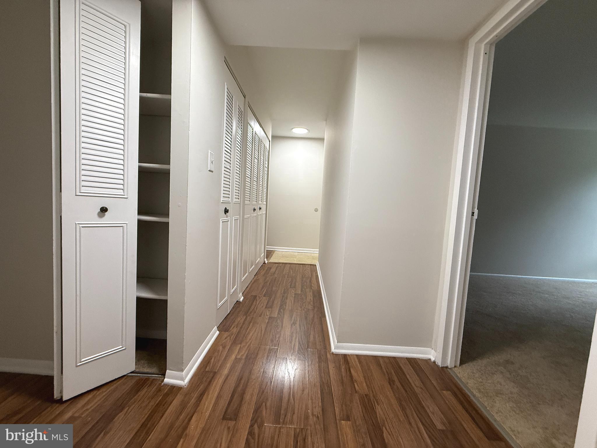 8689 Greenbelt Road, Unit 101 Greenbelt, MD 20770 - Photo 16 of 27 a view of a hallway with wooden floor and staircase