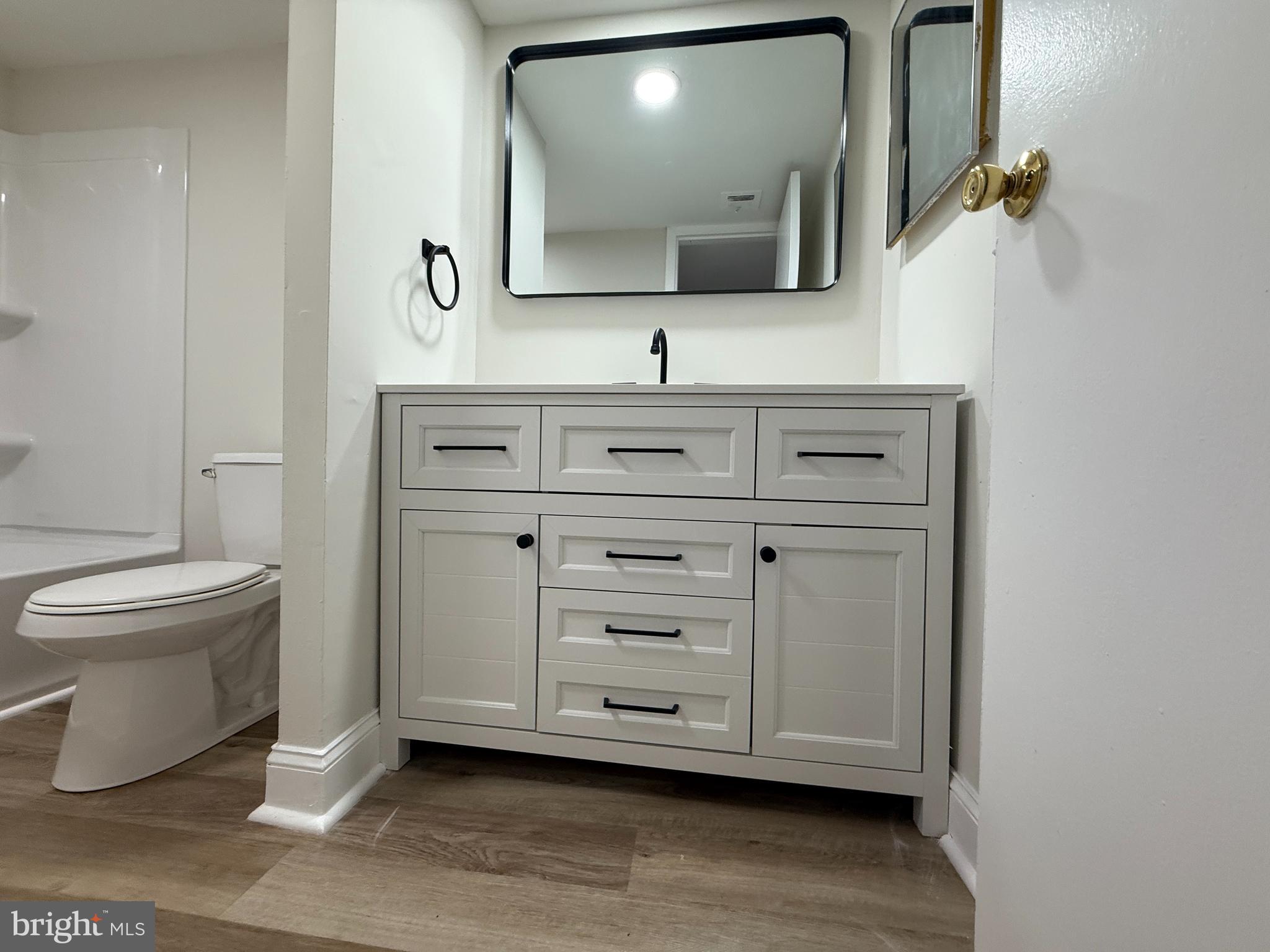 8689 Greenbelt Road, Unit 101 Greenbelt, MD 20770 - Photo 17 of 27 a bathroom with a toilet sink and mirror