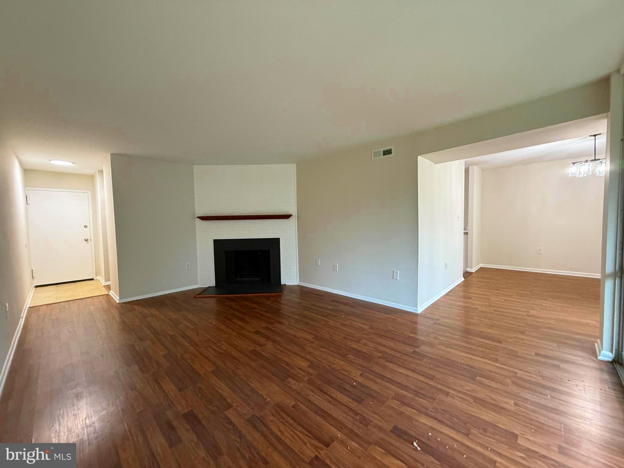 8689 Greenbelt Road, Unit 101 Greenbelt, MD 20770 - Photo 5 of 27 a view of empty room with wooden floor and fireplace