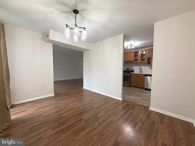 a view of a room with wooden floor and kitchen
