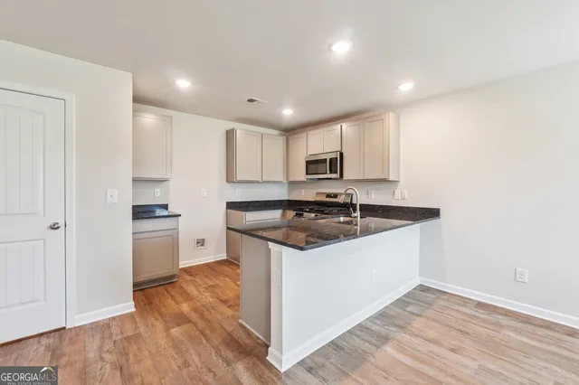 a kitchen with granite countertop a sink and a stove top oven