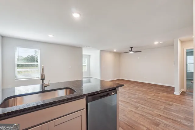 a kitchen with a sink cabinets and wooden floor