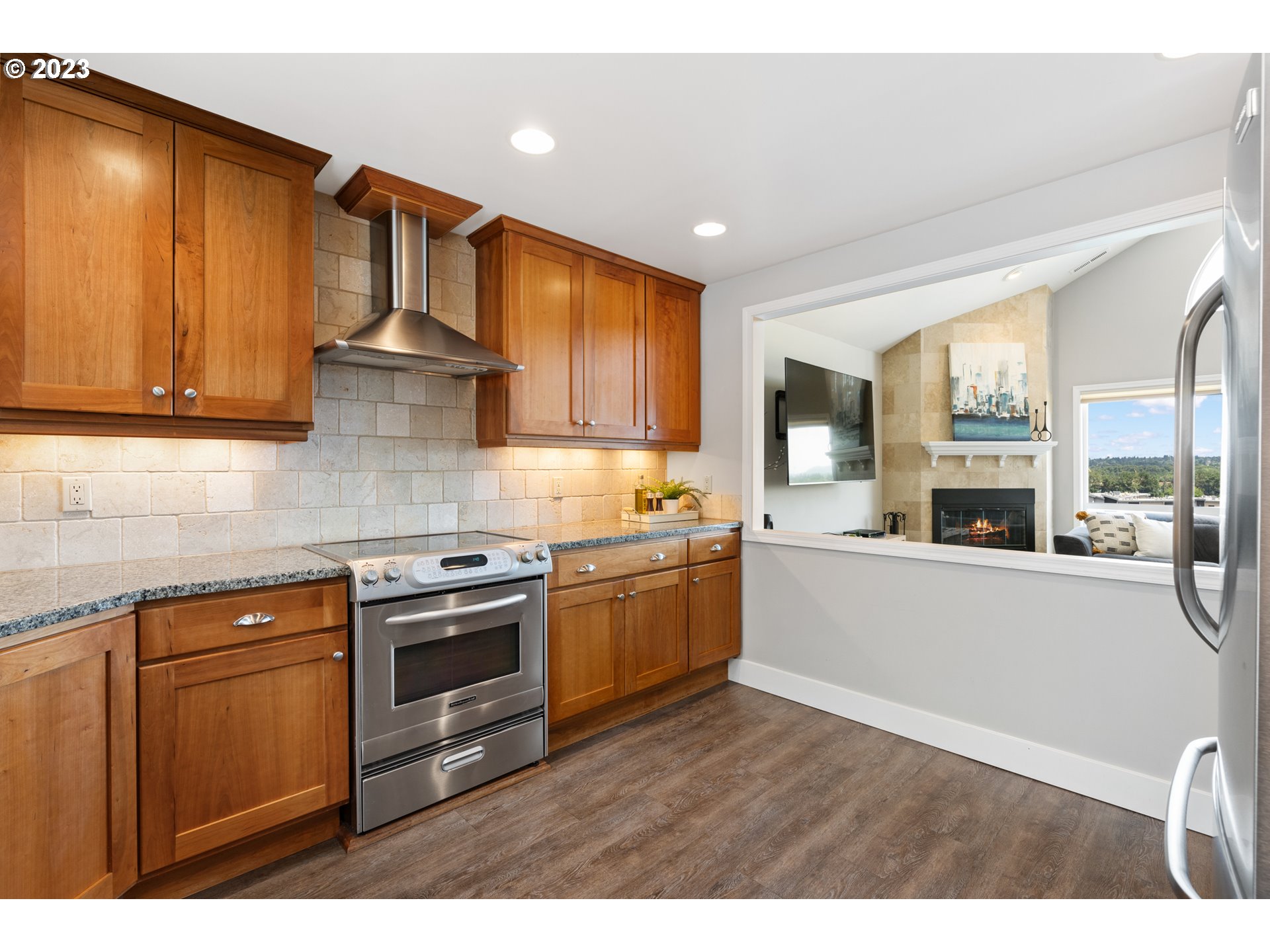 5411 Southwest View Point Terrace Portland, OR 97239 - Photo 11 of 44 a kitchen with stainless steel appliances wooden cabinets and a stove top oven