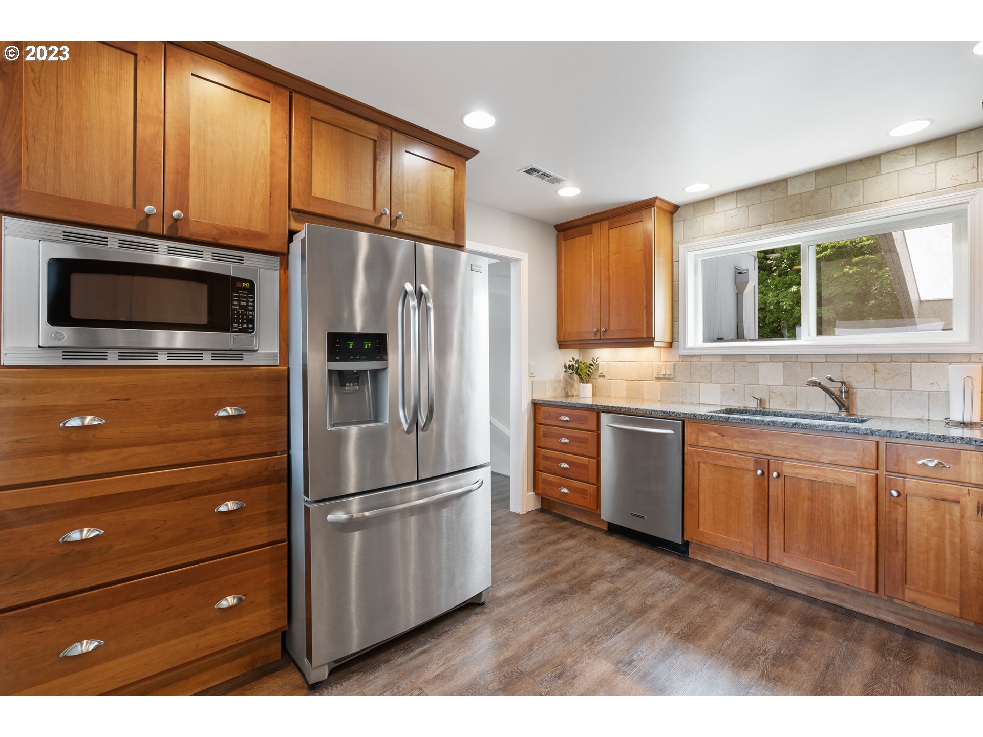 5411 Southwest View Point Terrace Portland, OR 97239 - Photo 9 of 44 a kitchen with granite countertop a refrigerator stove and sink
