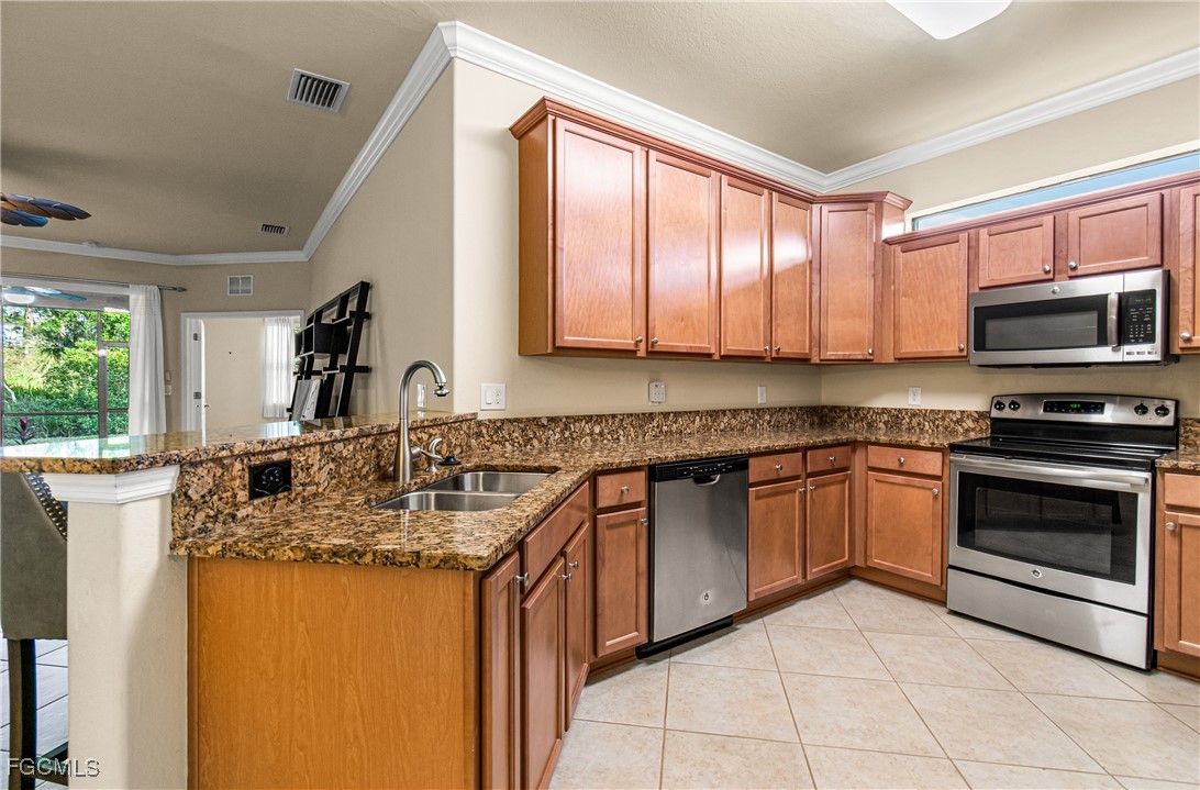 9101 Water Tupelo Road Fort Myers, FL 33912 - Photo 17 of 43 a kitchen with stainless steel appliances granite countertop a stove sink and microwave