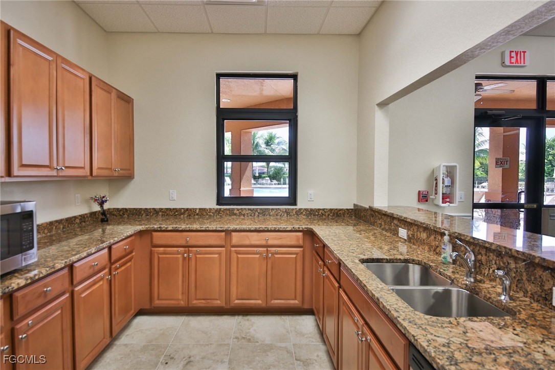 9101 Water Tupelo Road Fort Myers, FL 33912 - Photo 37 of 43 a kitchen with granite countertop a sink stove and cabinets