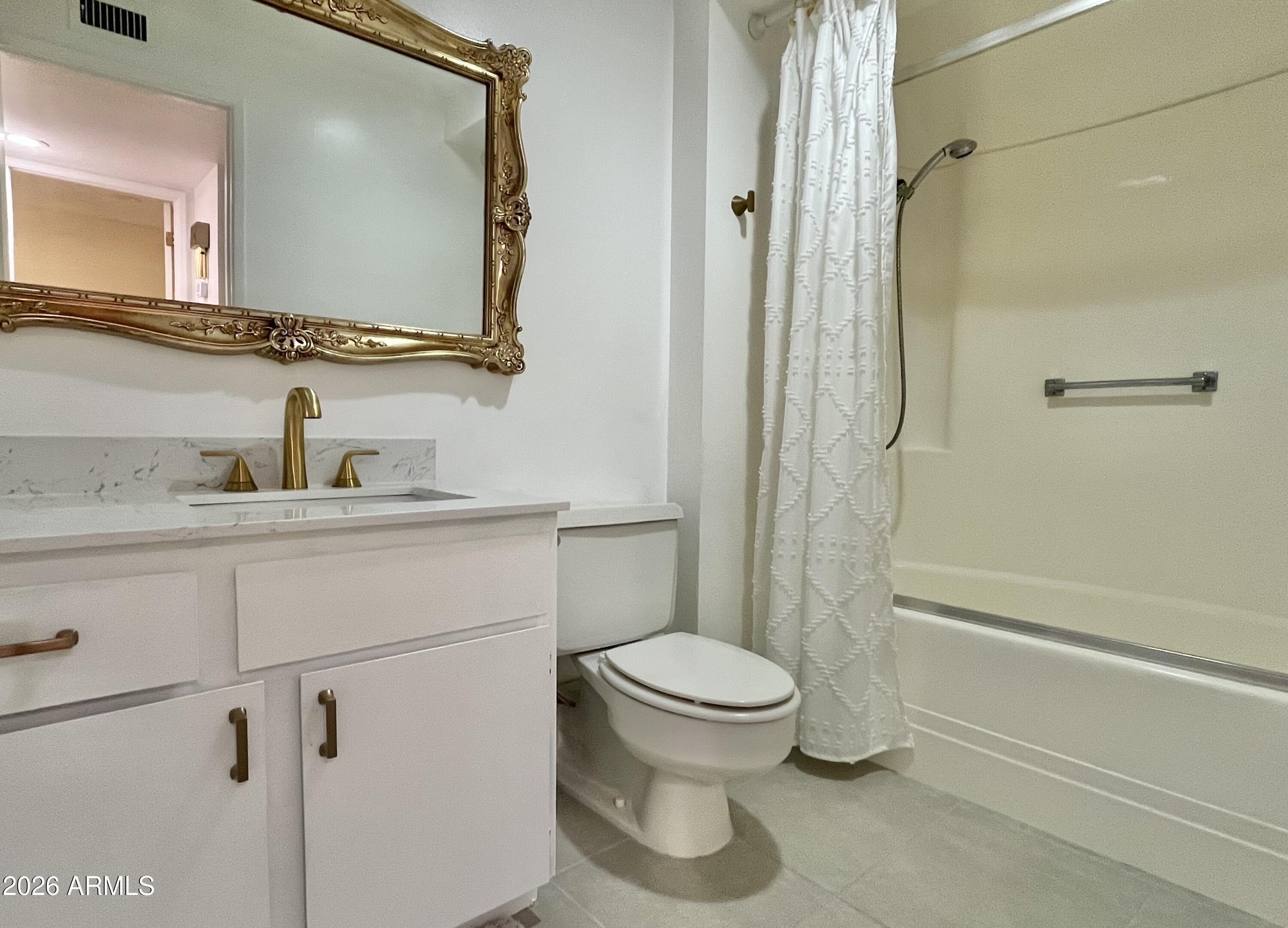 9718 West Oak Ridge Drive Sun City, AZ 85351 - Photo 13 of 41 a bathroom with a toilet sink vanity and mirror