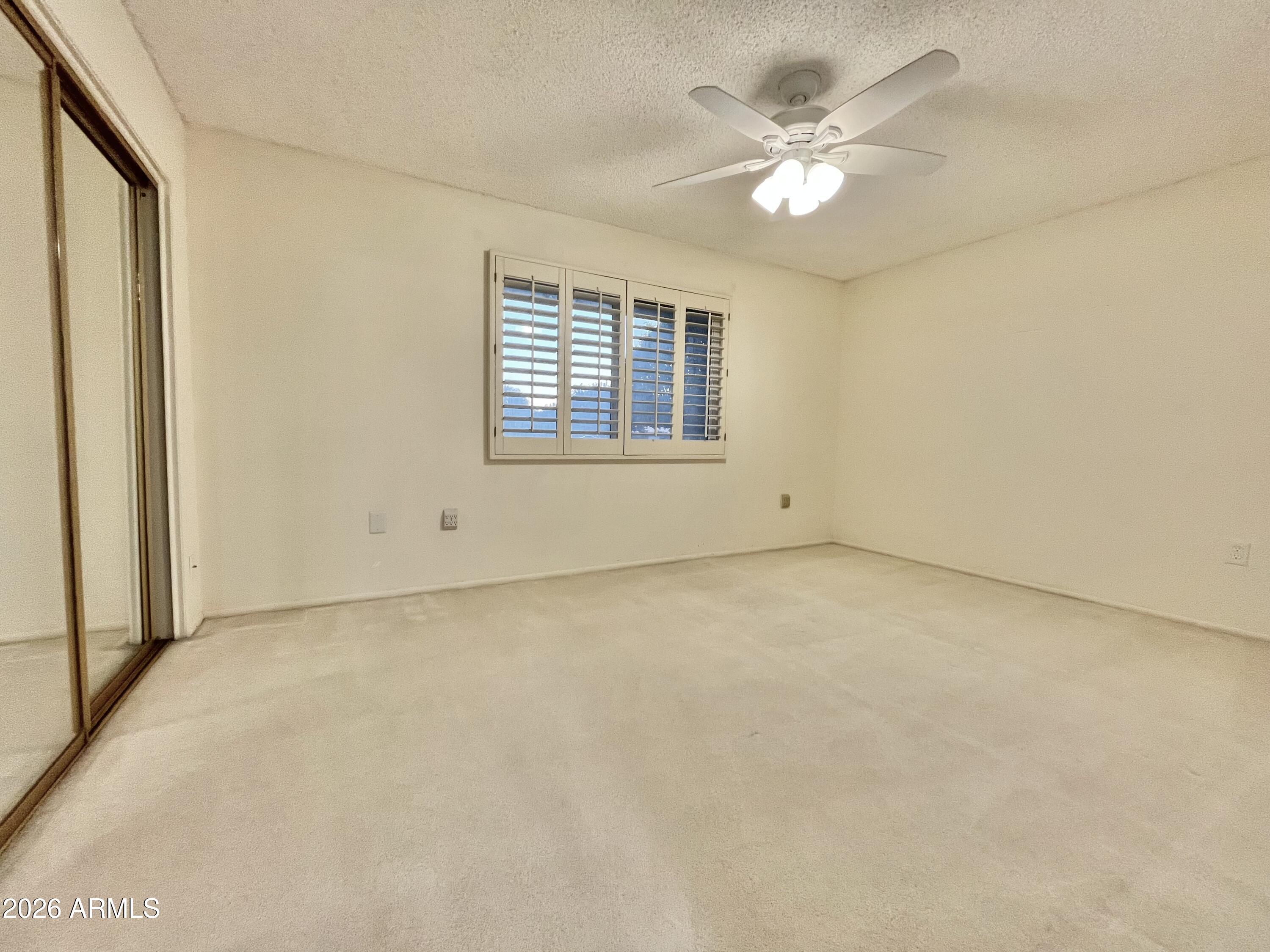 9718 West Oak Ridge Drive Sun City, AZ 85351 - Photo 18 of 41 an empty room with a chandelier fan and windows