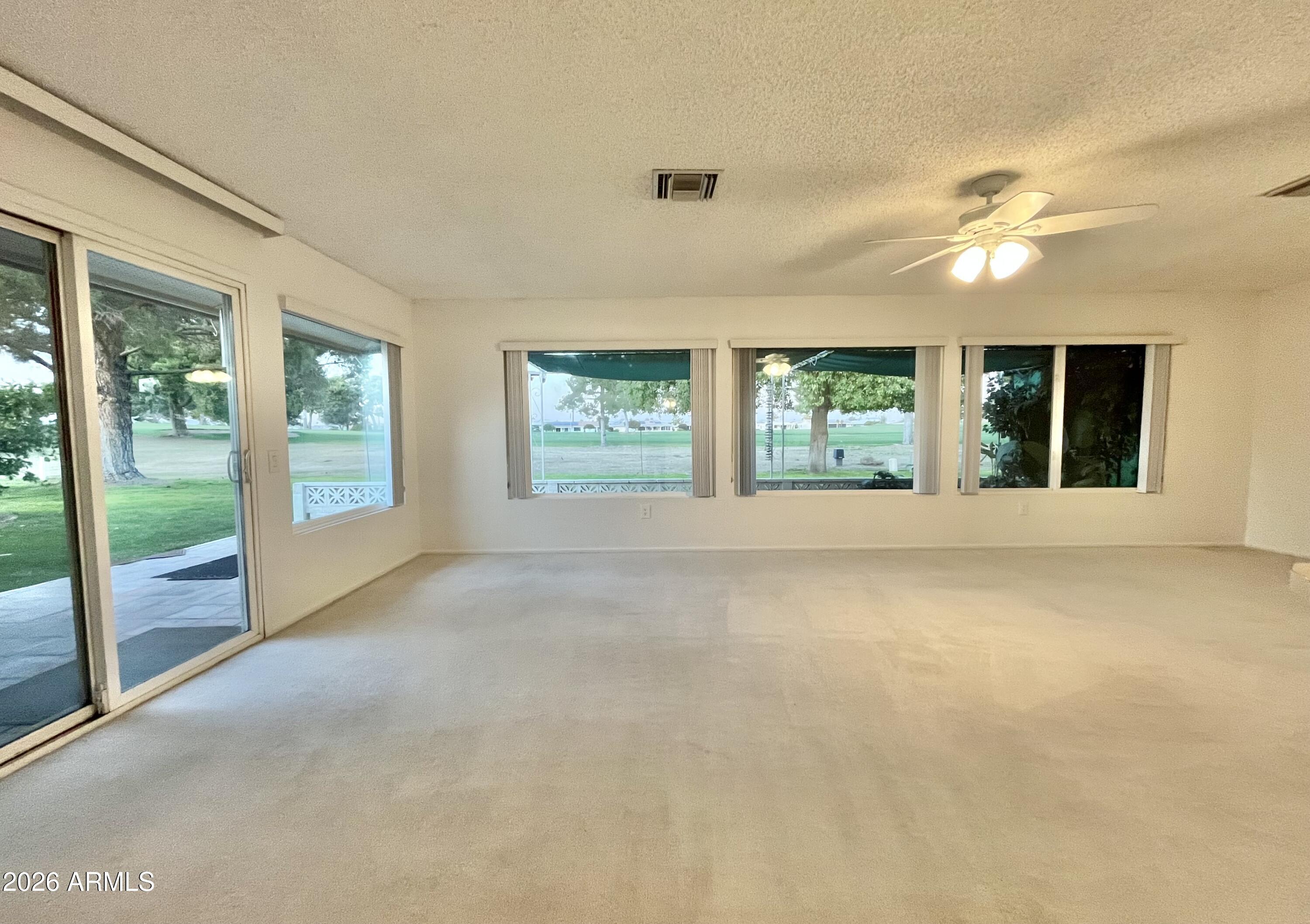 9718 West Oak Ridge Drive Sun City, AZ 85351 - Photo 2 of 41 a view of an empty room with glass door and balcony
