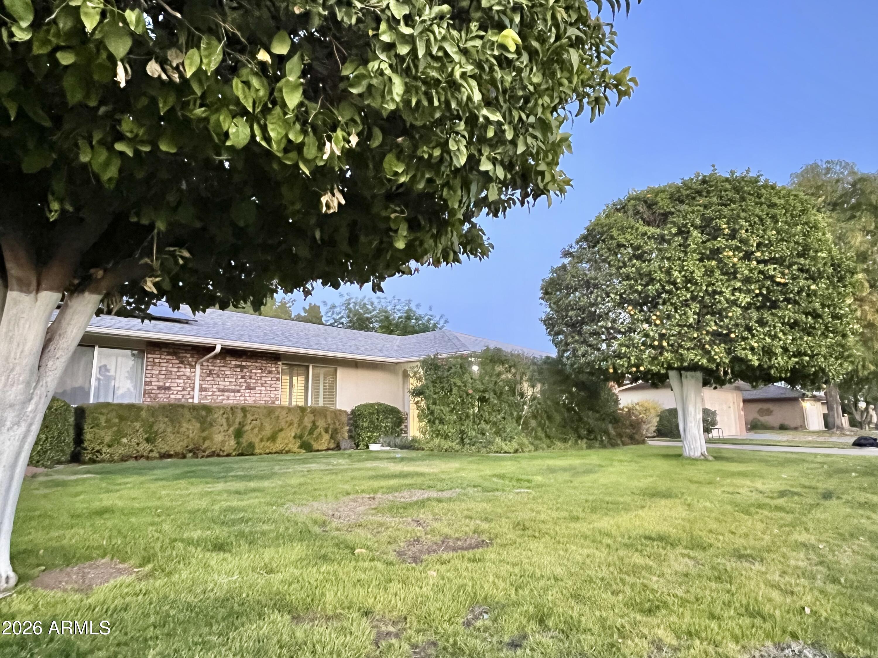 9718 West Oak Ridge Drive Sun City, AZ 85351 - Photo 35 of 41 a front view of a house with a garden