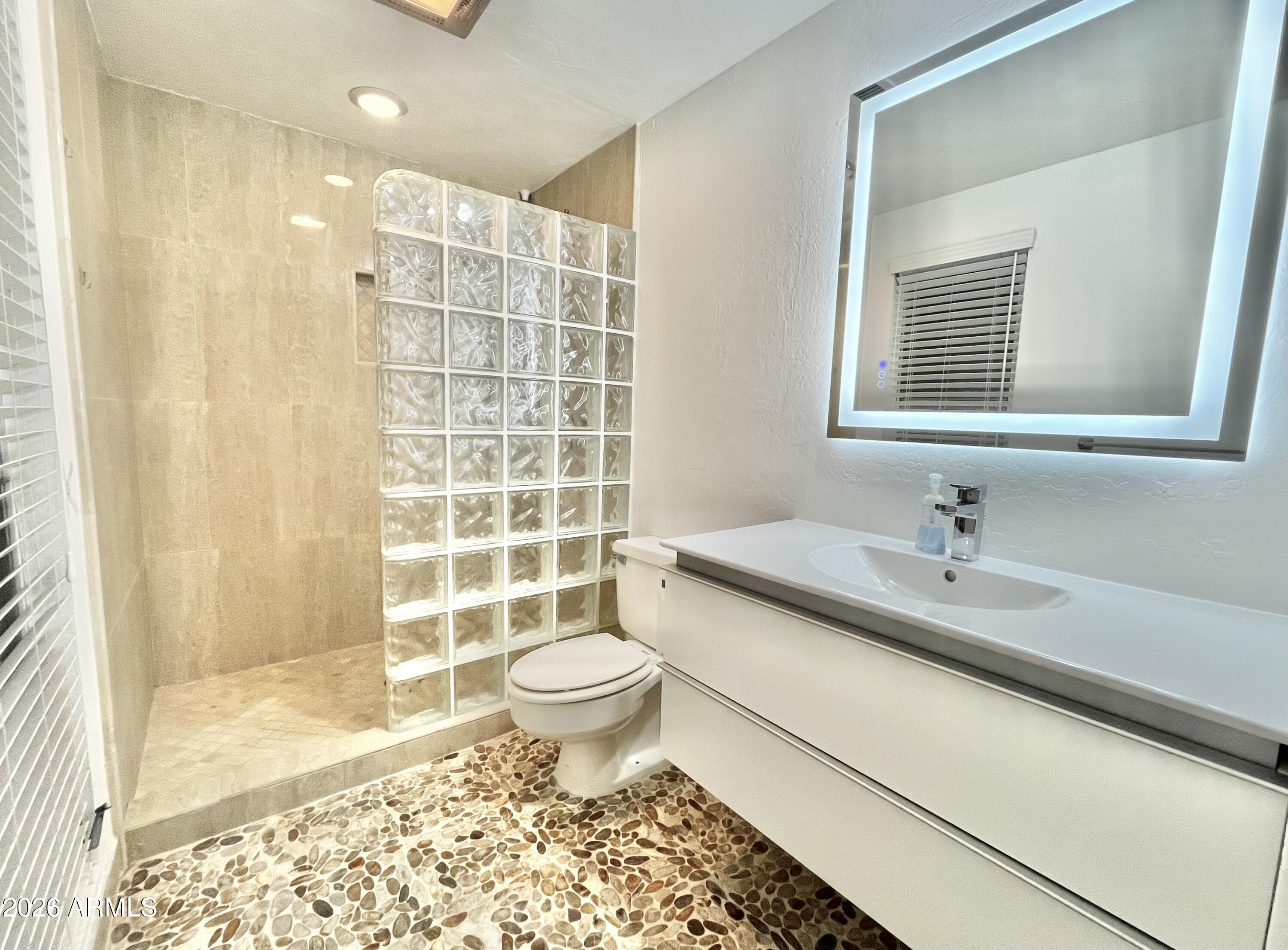 9718 West Oak Ridge Drive Sun City, AZ 85351 - Photo 5 of 41 a bathroom with a sink toilet a mirror and shower