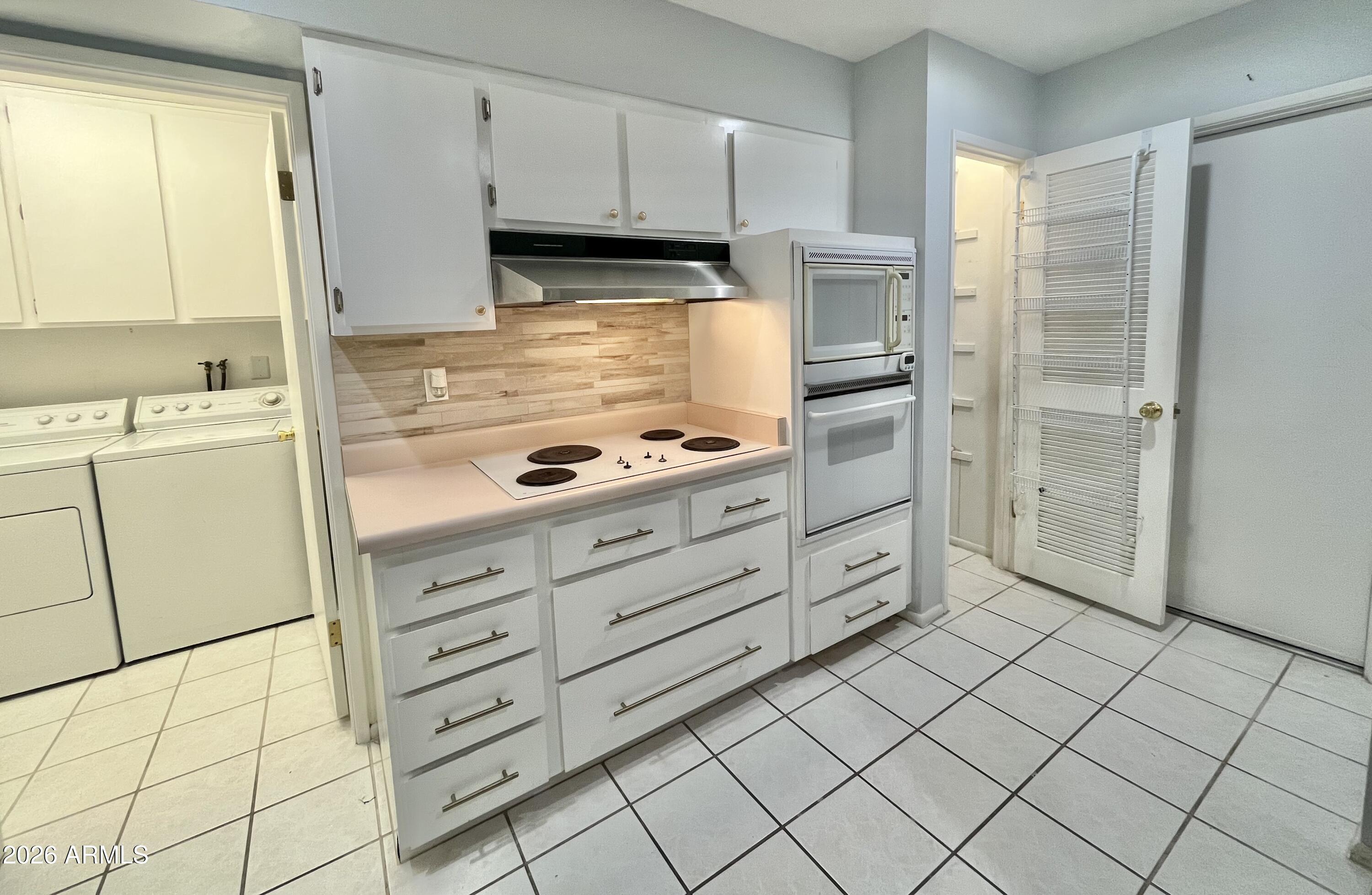 9718 West Oak Ridge Drive Sun City, AZ 85351 - Photo 9 of 41 a kitchen with cabinets and a stove top oven