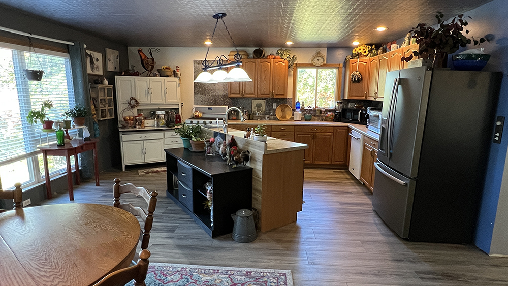 18510 Sand Road Fulton, IL 61252 - Photo 4 of 54 a kitchen with stainless steel appliances granite countertop a refrigerator a sink dishwasher a stove and a dining table with wooden floor
