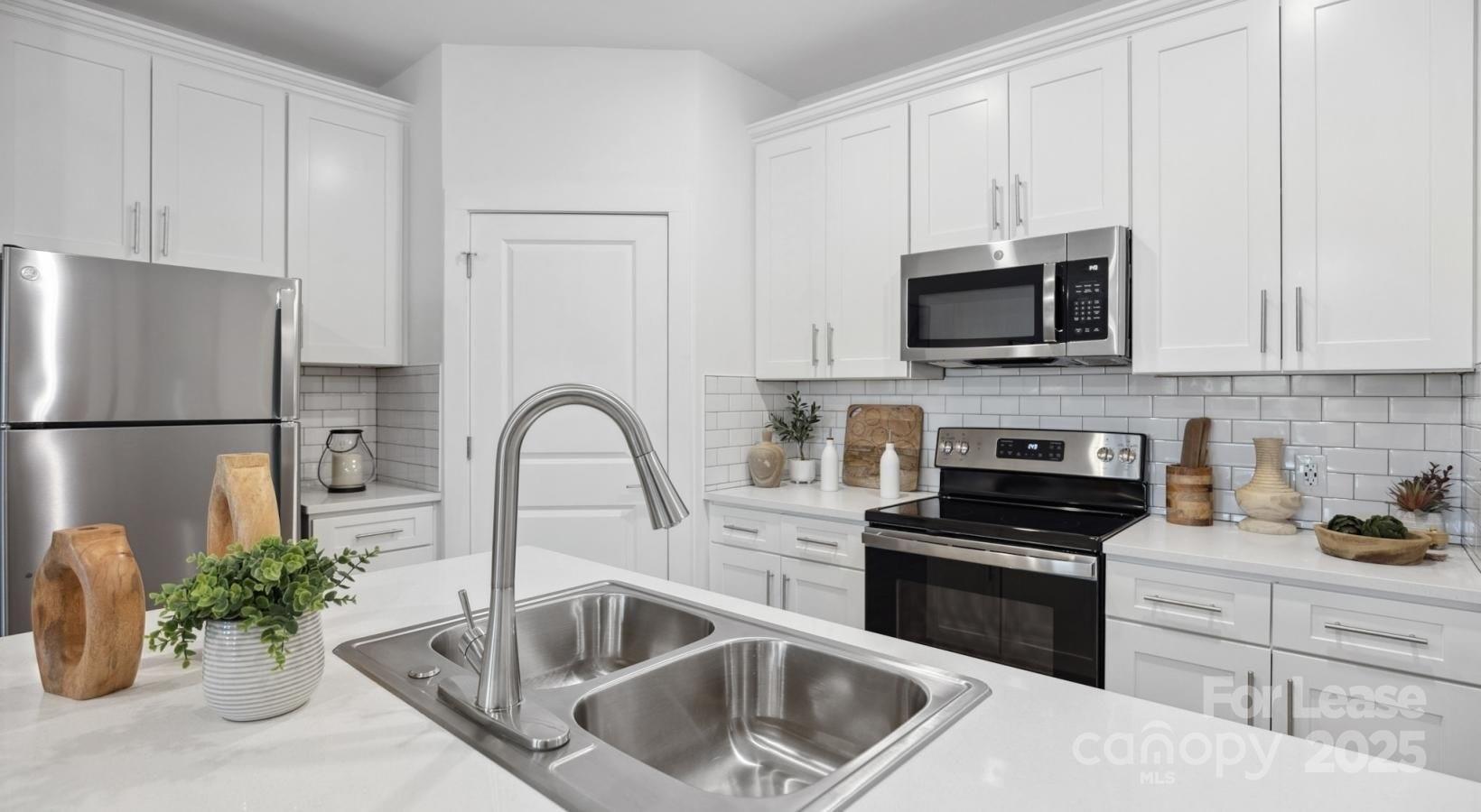 129 Blume Road, Unit MEANDER Mooresville, NC 28117 - Photo 22 of 32 a kitchen with a sink and a stove top oven