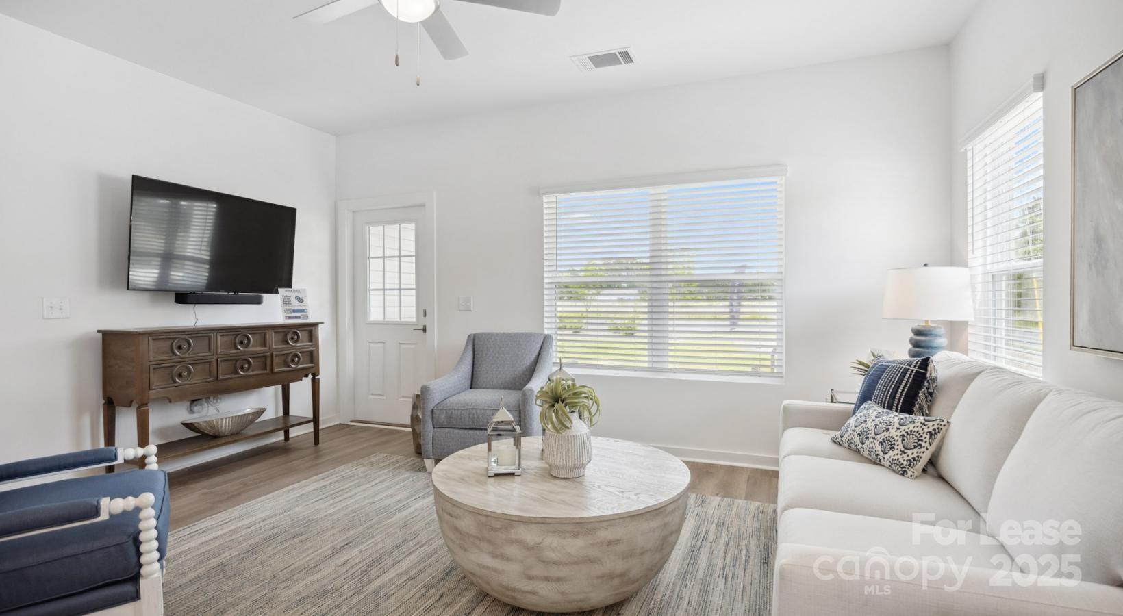 129 Blume Road, Unit MEANDER Mooresville, NC 28117 - Photo 9 of 32 a living room with furniture a fireplace and a flat screen tv