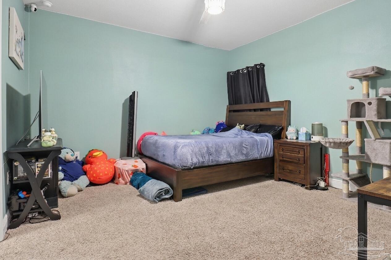 335 Cayden Way Cantonment, FL 32533 - Photo 11 of 30 a bedroom with furniture and a flat tv screen