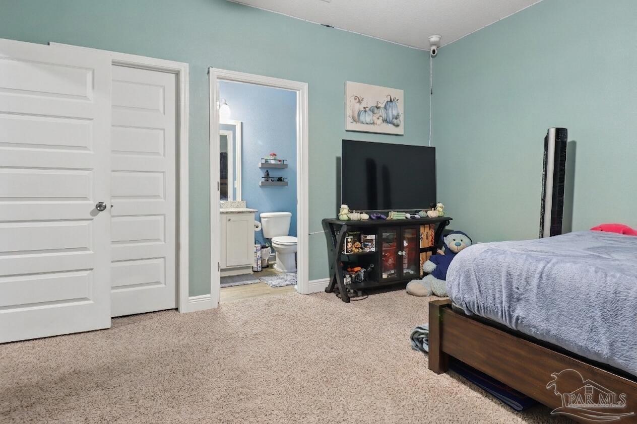 335 Cayden Way Cantonment, FL 32533 - Photo 12 of 30 a bedroom with a bed and a flat tv screen