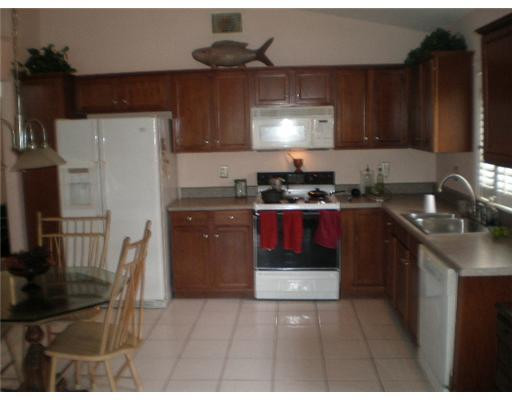 9727 Tavernier Drive Boca Raton, FL 33496 - Photo 14 of 16 a kitchen with a sink a stove and cabinets