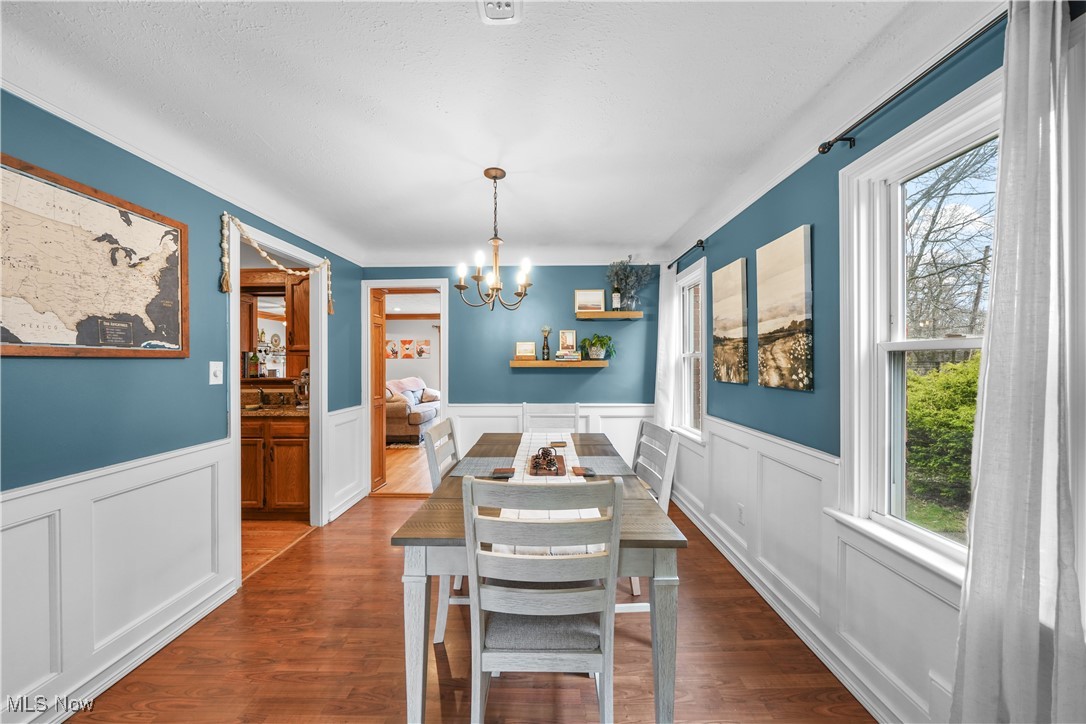 4819 Westbourne Road Cleveland, OH 44124 - Photo 6 of 39 Dining space featuring a wainscoted wall, dark wood-style floors, and a notable chandelier