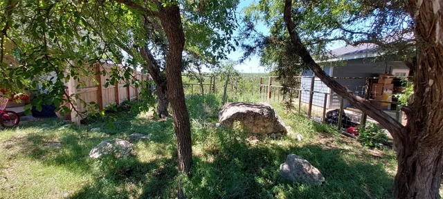a backyard of a house with lots of green space and fountain