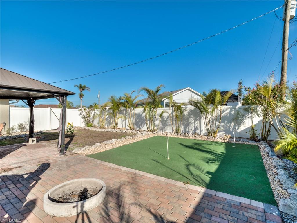 20621 Coconut Drive Estero, FL 33928 - Photo 33 of 37 a backyard of a house with table and chairs under an umbrella