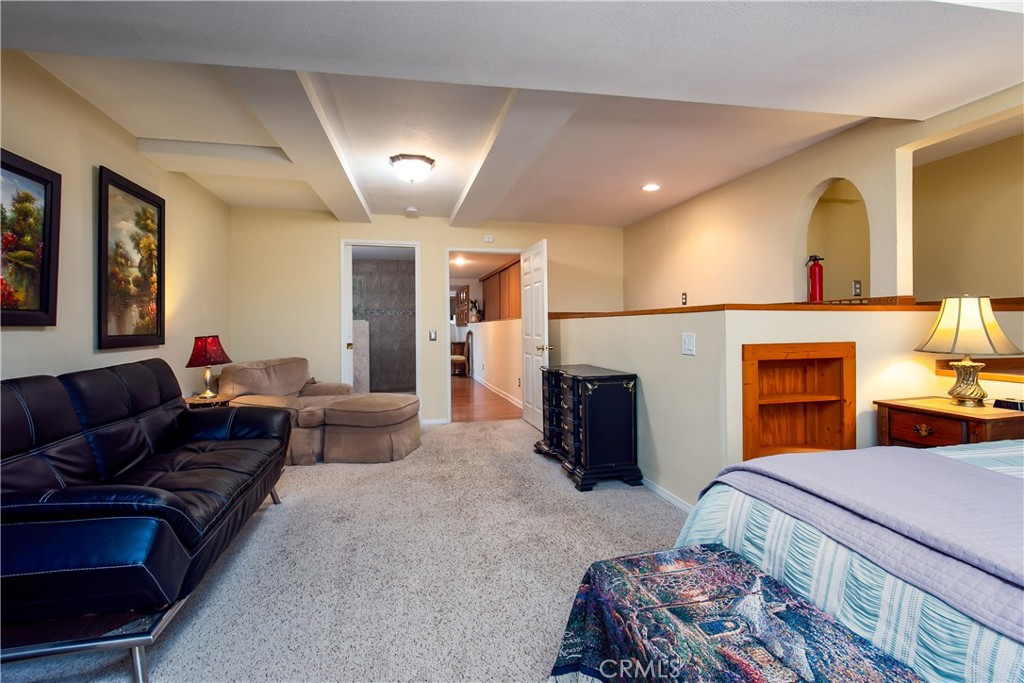 10960 Steinhoff Road Frazier Park, CA 93225 - Photo 42 of 46 A spacious secondary angle of the 5th lower-level bedroom suite. This wide perspective showcases the room's extensive square footage, bright recessed ceiling lights, and neutral carpeting, while illustrating how the room opens up to a relaxed sitting lounge area perfect for a multi-generational living setup.