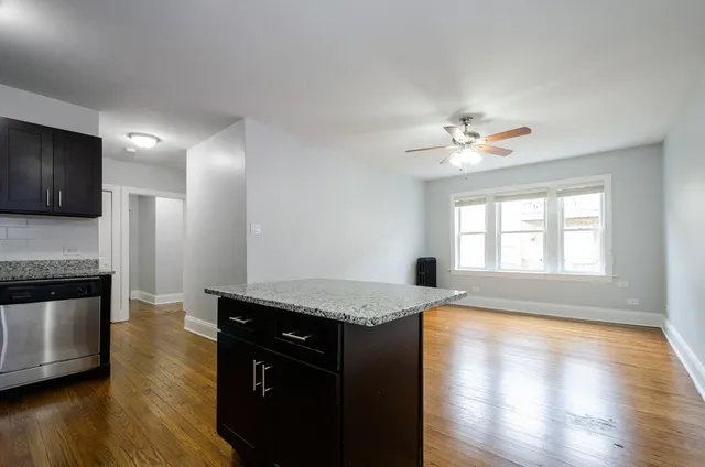 a kitchen with granite countertop a stove a sink and a microwave