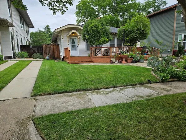 a front view of a house with garden and trees