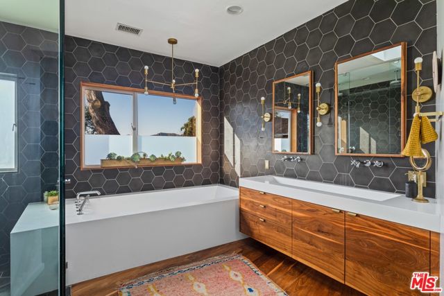 a bathroom with a tub and a large mirror