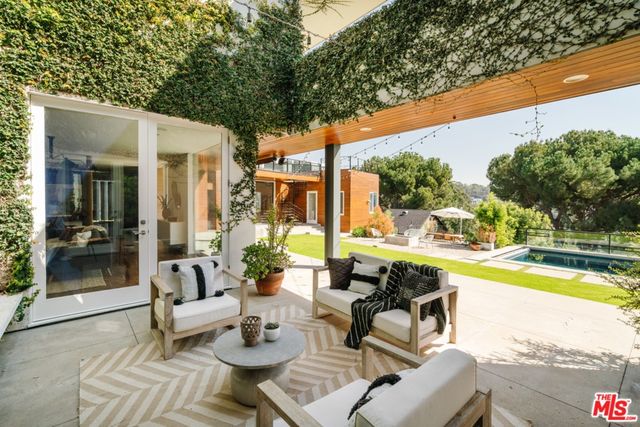 a view of a patio with couches table and chairs and potted plants