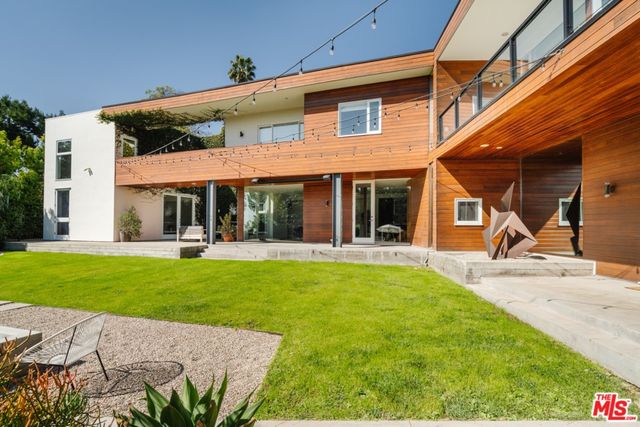a view of a house with backyard sitting area and swimming pool