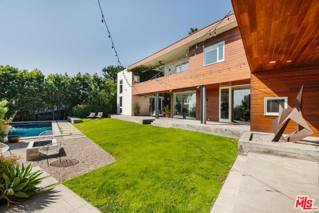 a view of a house with a table and chairs in patio