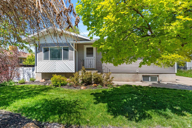 415 East 1150th Street North Logan, UT 84341 - Photo 1 of 38 Exterior featuring gray siding, a prominent bay window with white trim, and a manicured front lawn