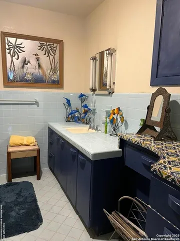 a bathroom with a sink a mirror and painting on the wall